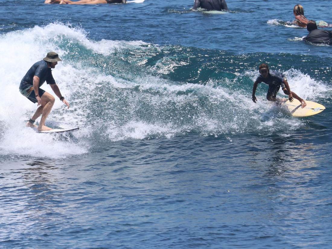 Shaun Morgan surfing with a young surfer